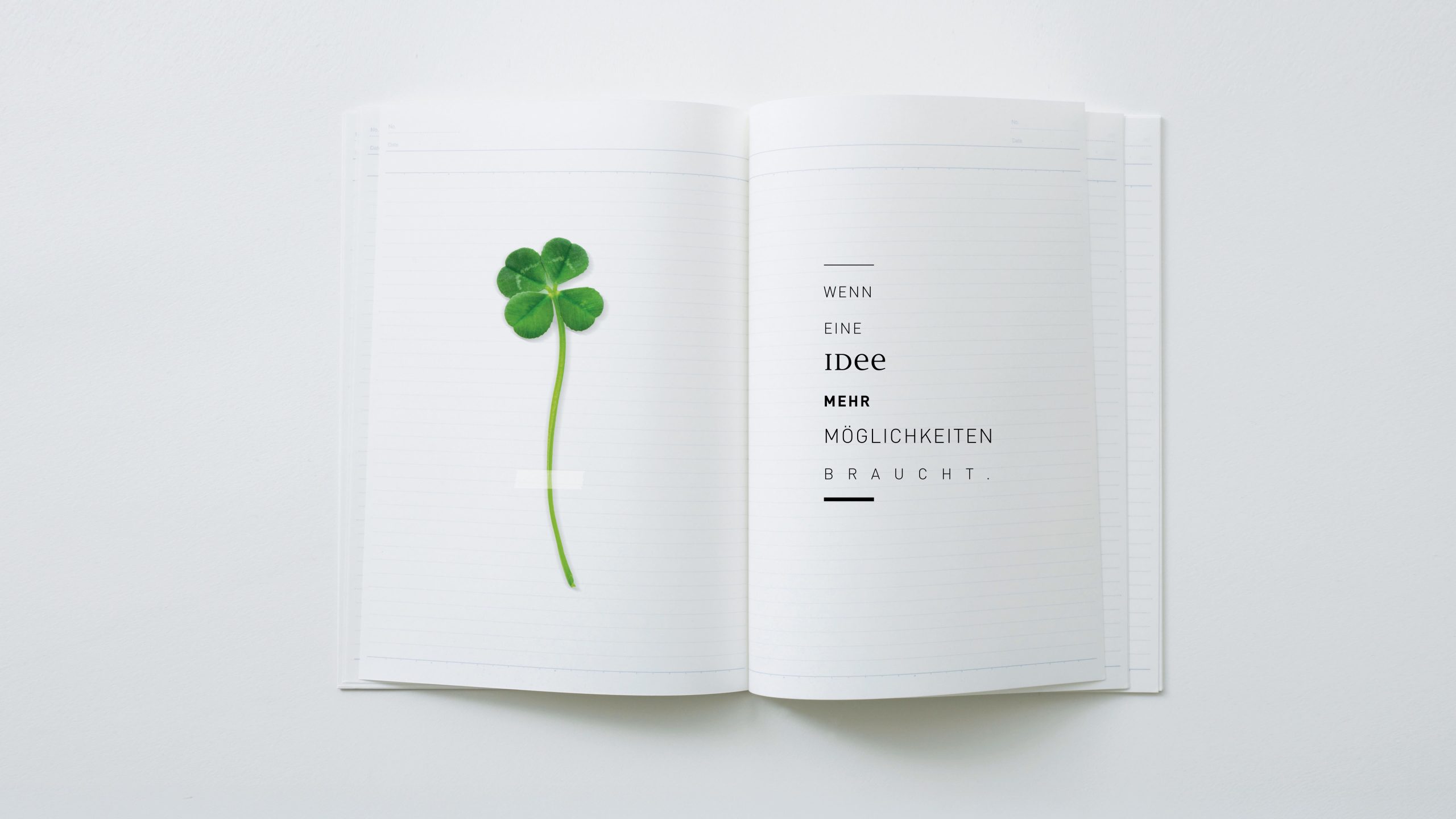 Offenes Notizbuch mit vierblättrigem Kleeblatt und typografischem Motiv – kreative Creative Direction Kampagne von Simone Rees als Branding Freelancer.